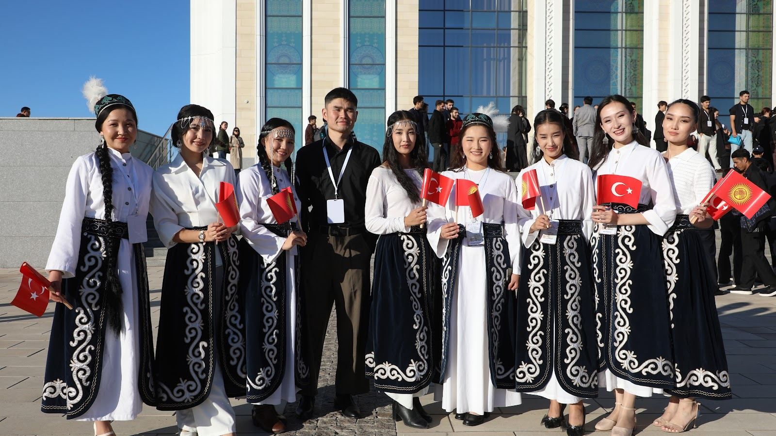 Участницы фестиваля в национальных костюмах с флагами Турции и Кыргызстана на ступенях театра